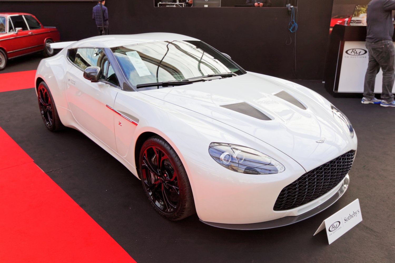 White sports coupe with hood vents and black wheels front view