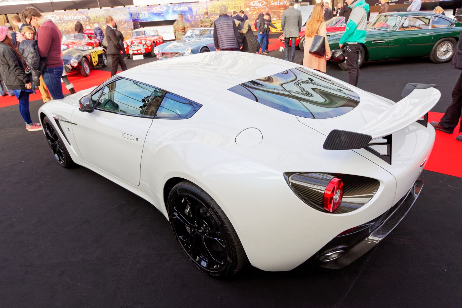 White coupe with carbon fiber rear wing and black wheels