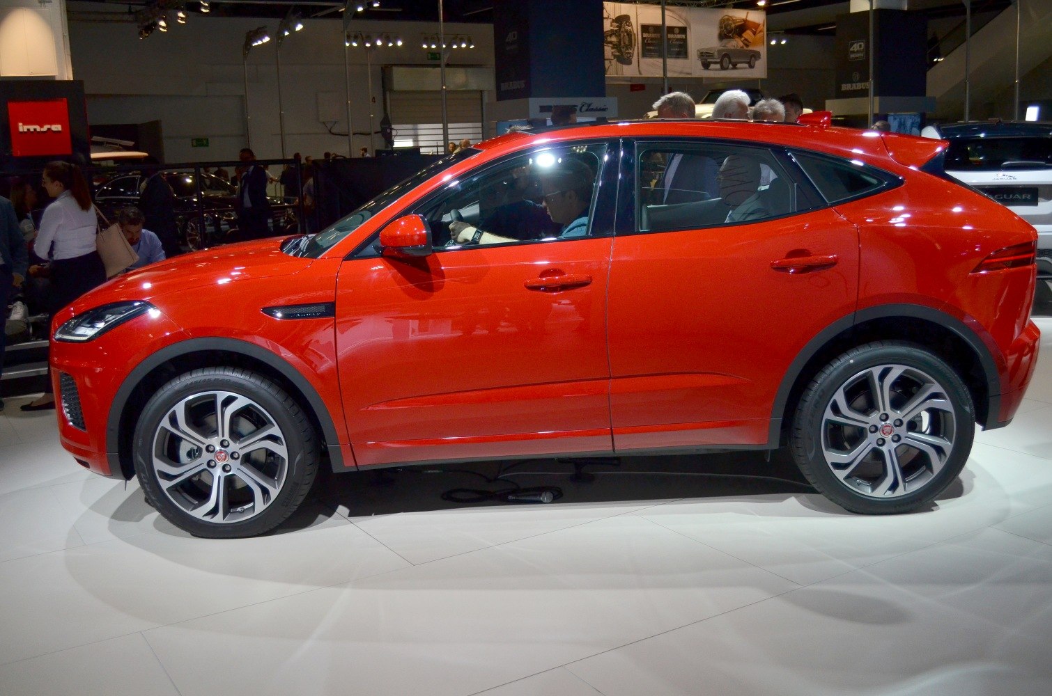 Side profile of red compact crossover SUV with alloy wheels.