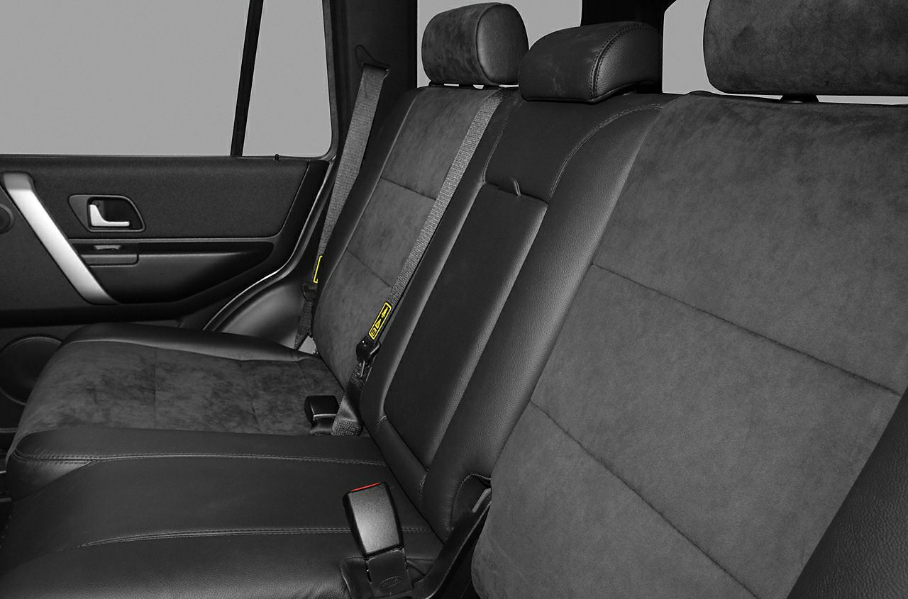 Rear seat interior with leather and fabric upholstery and integrated seat belts