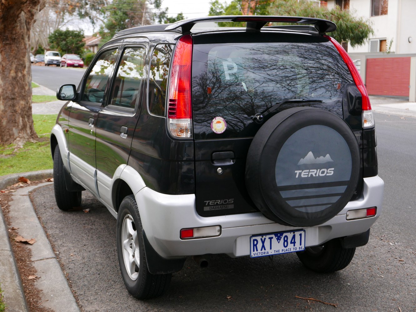 Rear view of compact SUV with spare wheel cover and roof spoiler