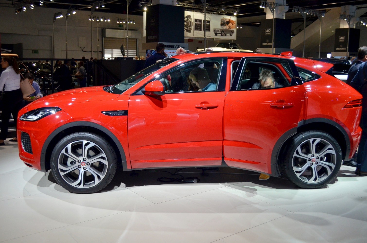 Red SUV side view with open rear door and alloy wheels
