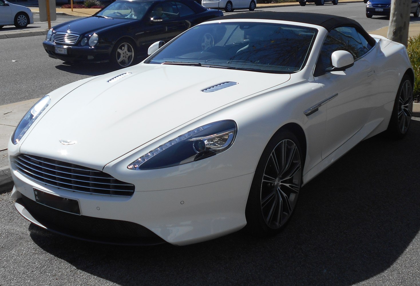 Sleek convertible front with grille, headlights, sporty wheels