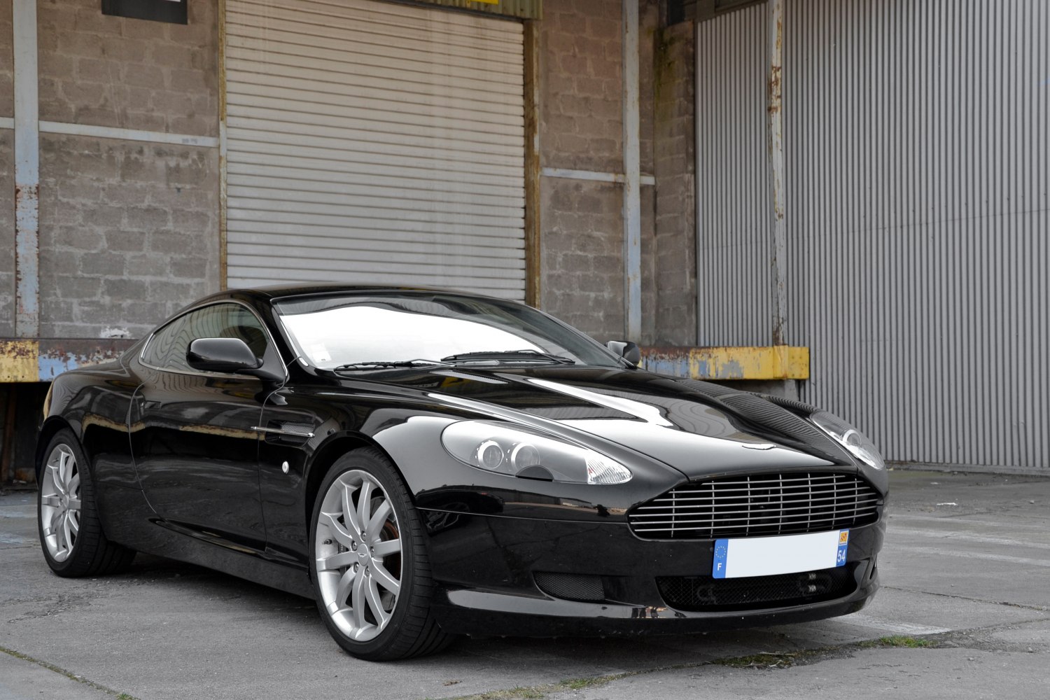 Glossy black luxury coupe with distinctive grille and sporty alloy wheels