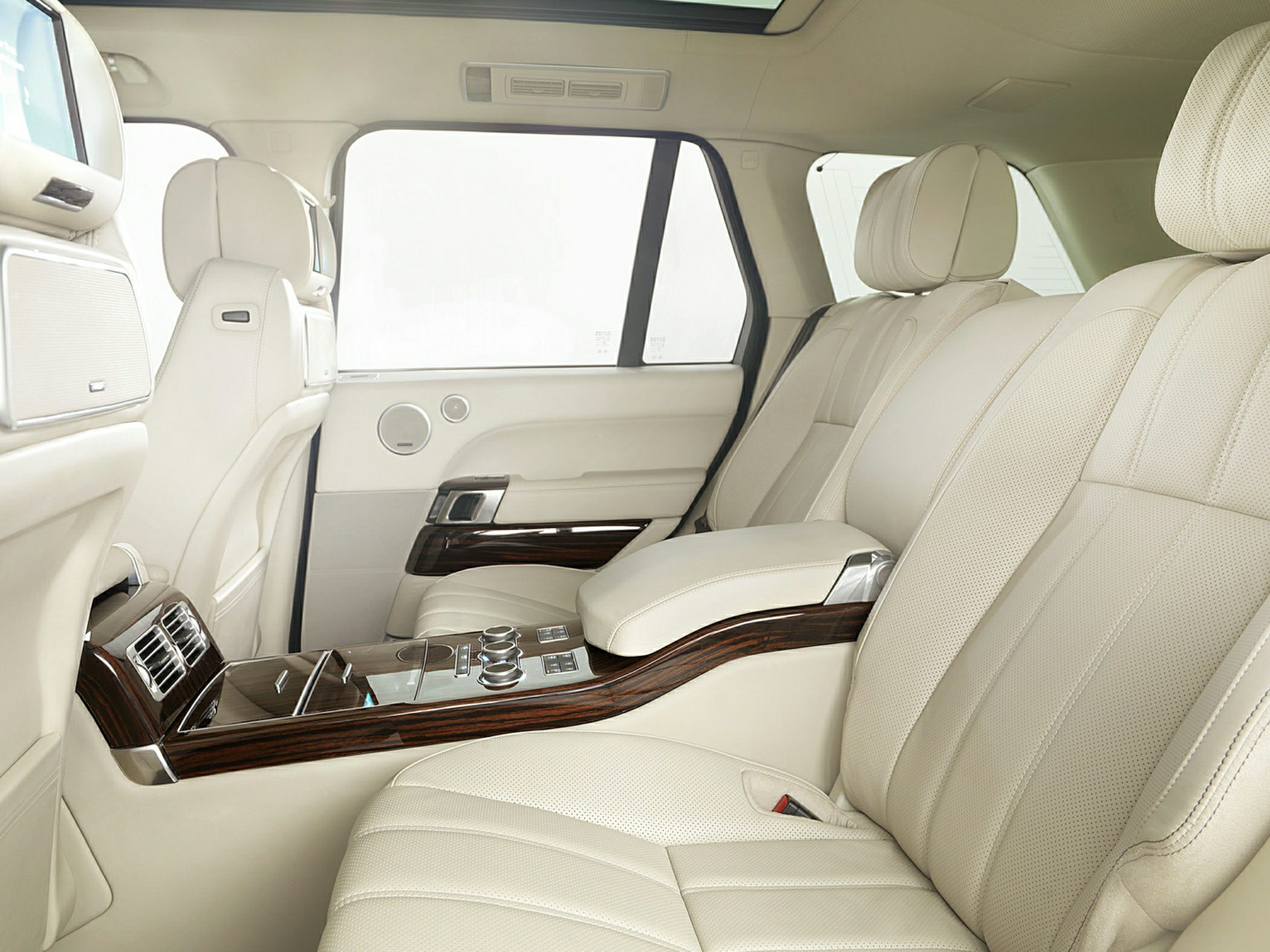 Luxury rear passenger interior with beige leather seats and wood trim center console