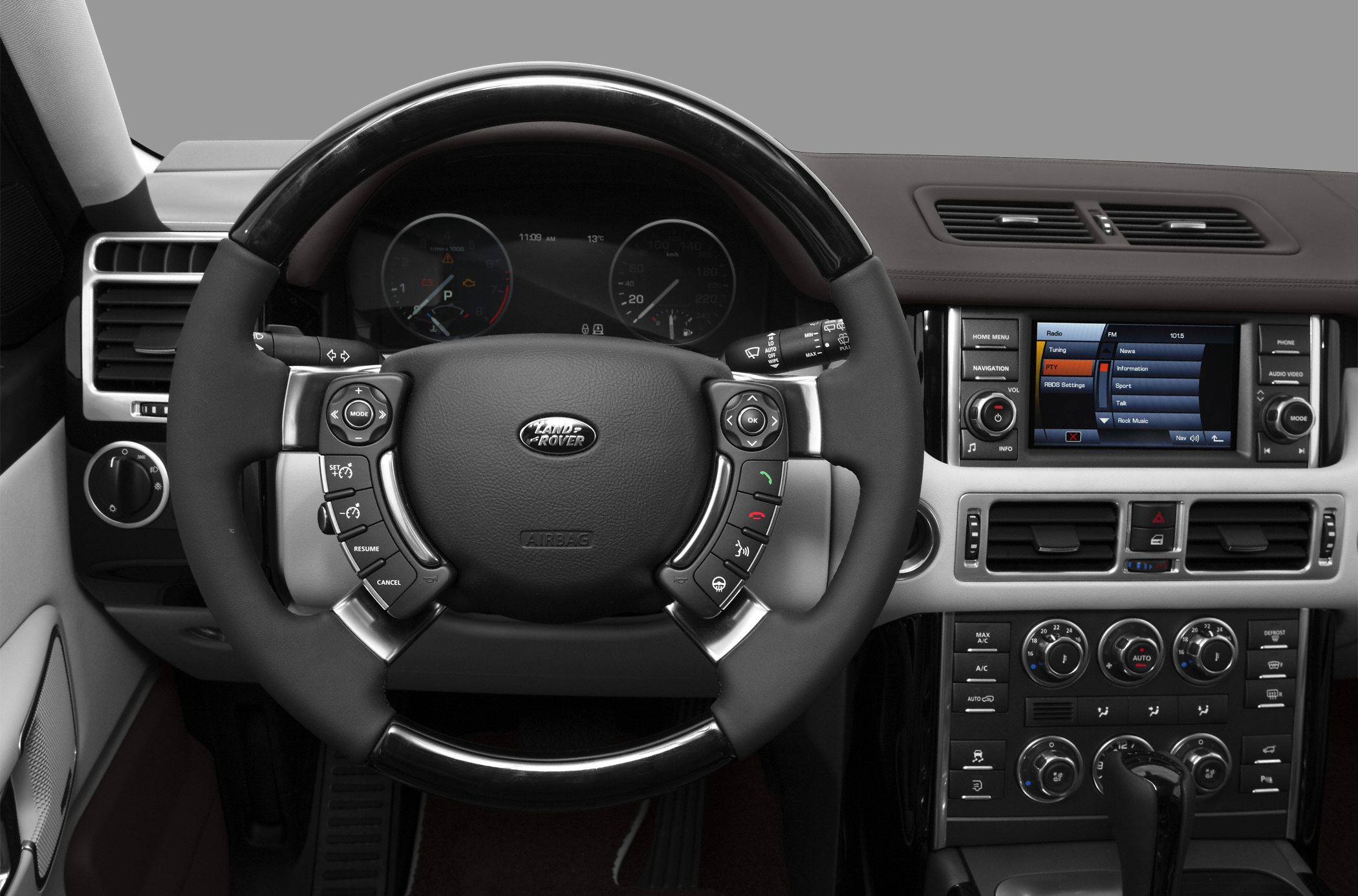 Steering wheel with controls and central dashboard with infotainment and climate control.