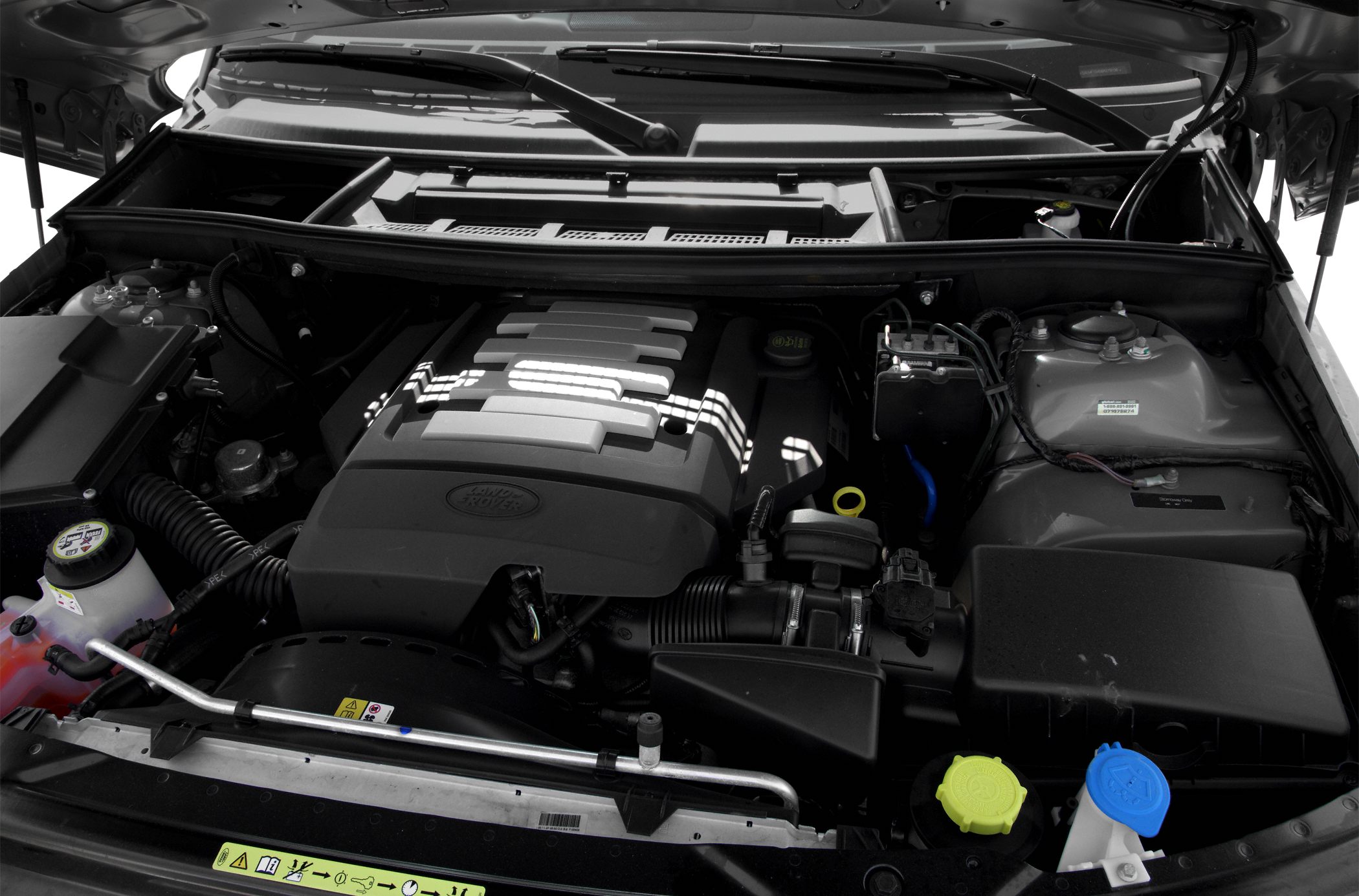 Detailed view of engine compartment with cover, caps, and various components