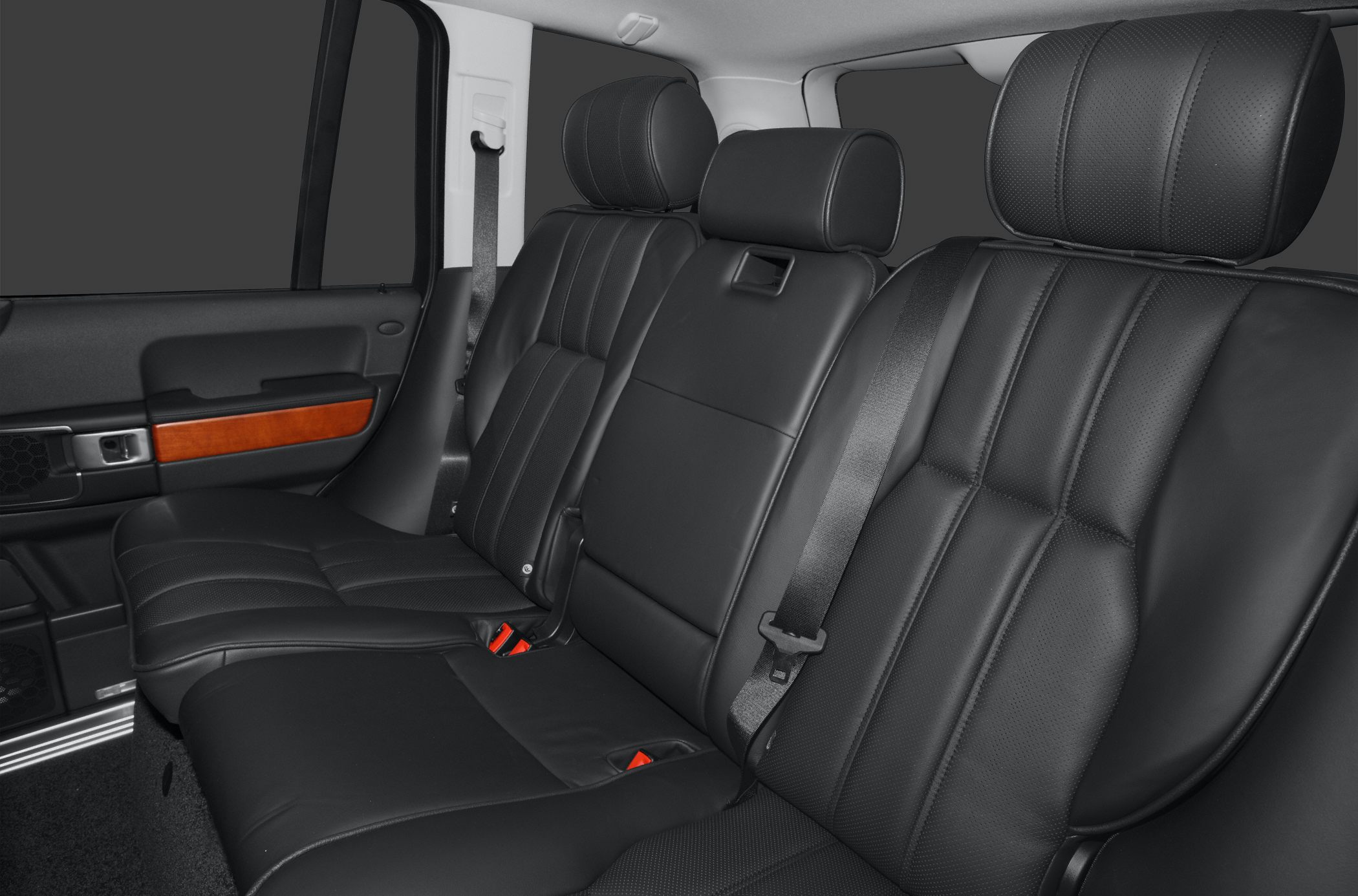Luxury rear seats with black leather upholstery and wood trim on door panel