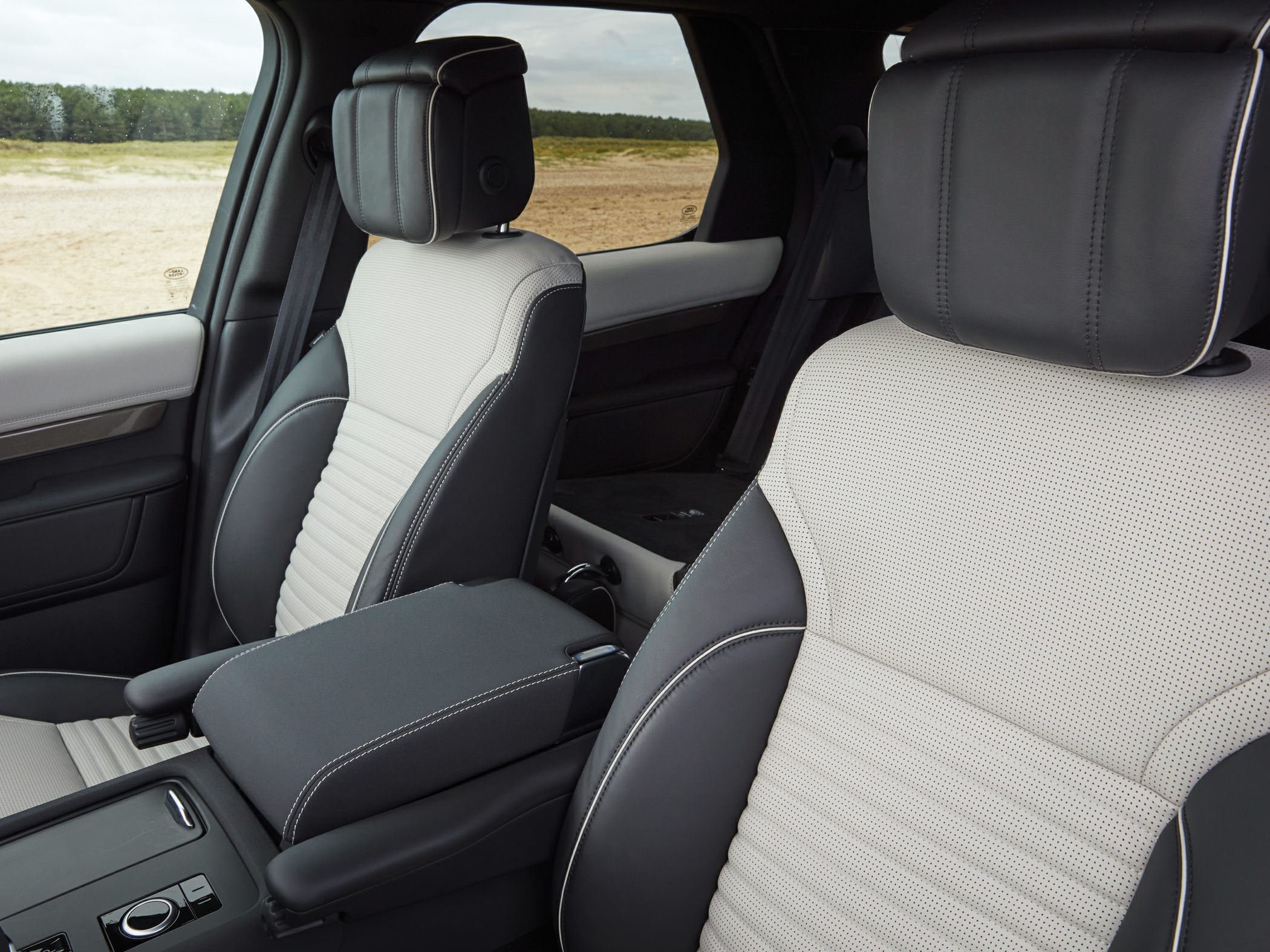 Two-tone luxury leather front seats with perforations and central armrest