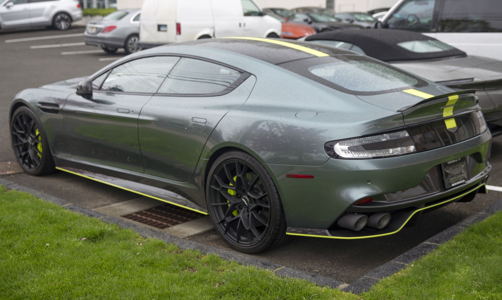 Rear and side profile of sporty luxury sedan with black wheels and quad exhausts