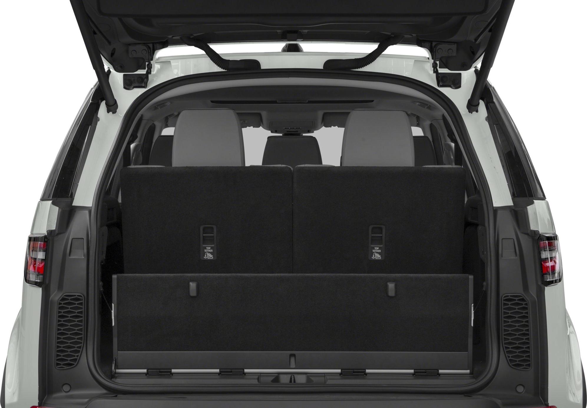 Open rear hatch revealing foldable third-row seats and cargo space