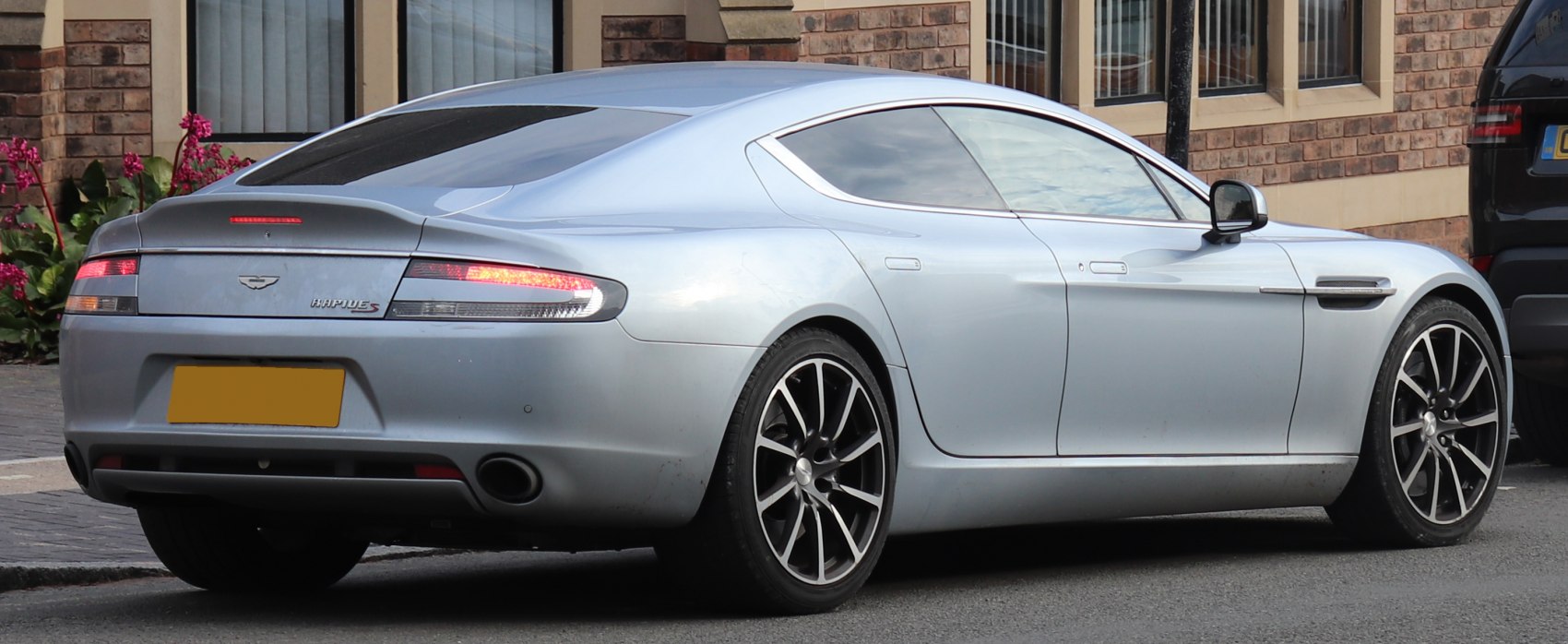 Rear side view of a luxury four-door coupe with sleek design and alloy wheels