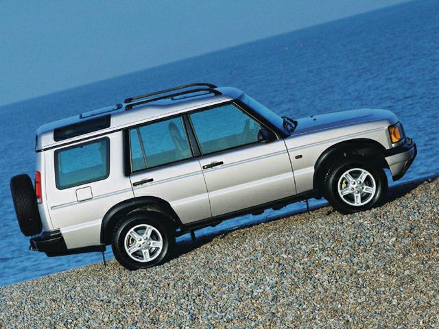 Silver off-road SUV climbing steep gravel slope with rugged, elevated profile.