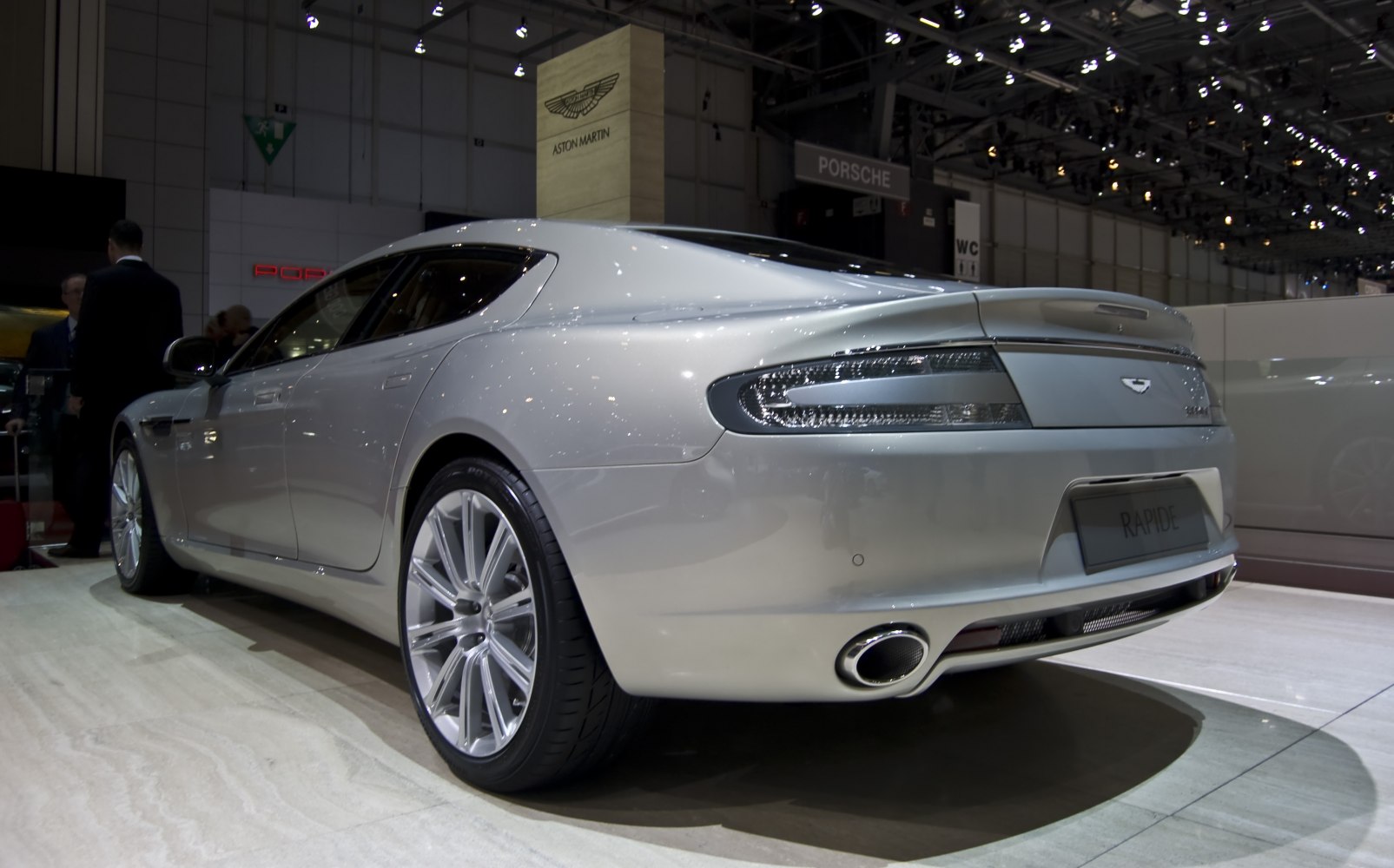 Rear side view of a luxury four-door sedan with sleek taillights and sporty exhaust.