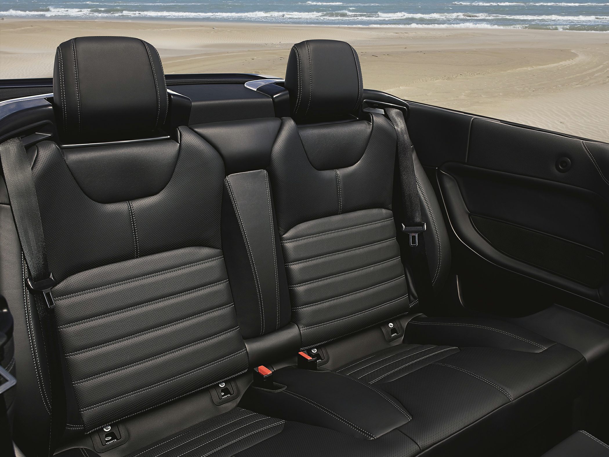 Black leather rear seats with detailed stitching and seat belts