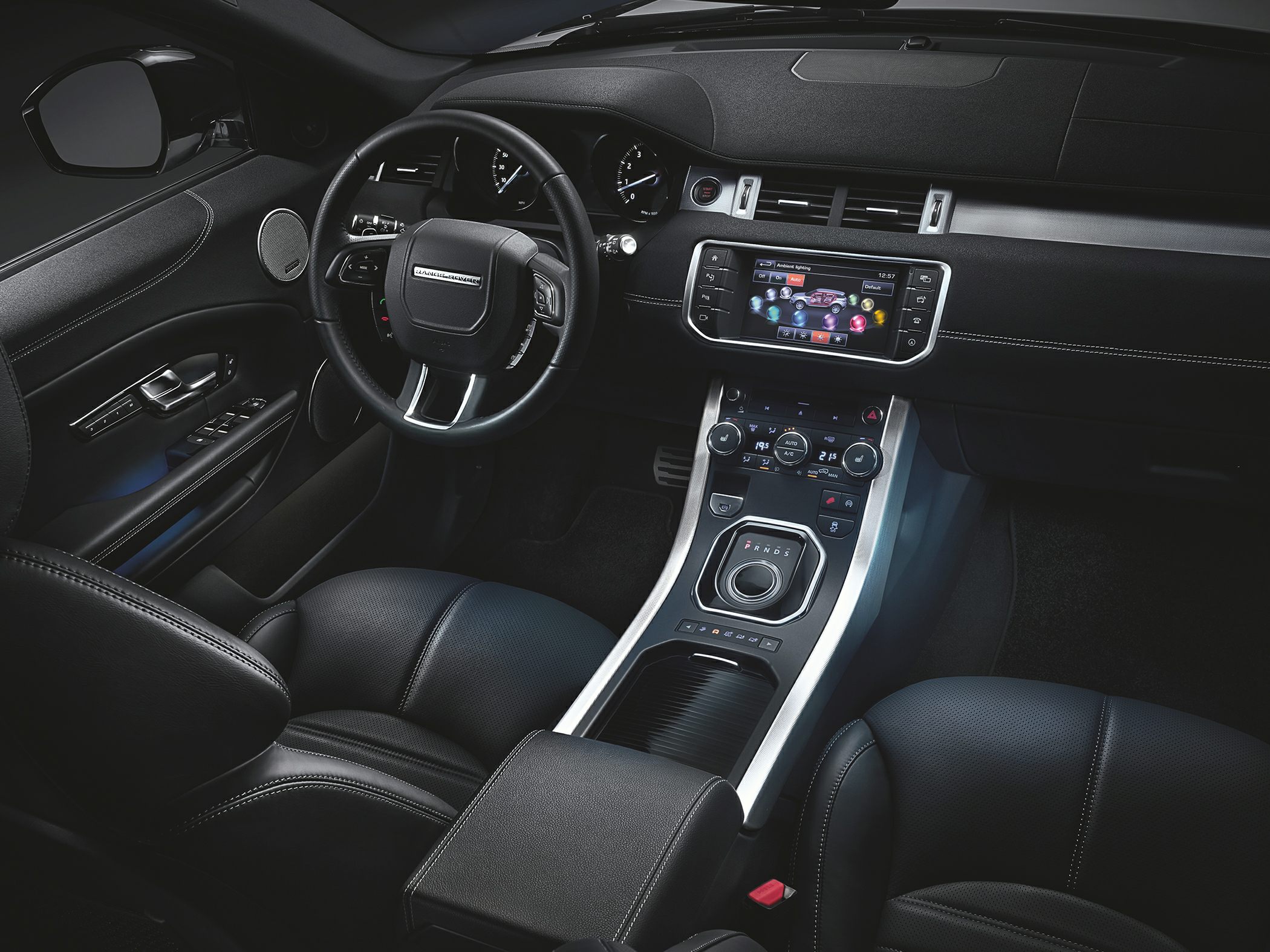 Car interior with touchscreen, rotary gear selector, and leather seats