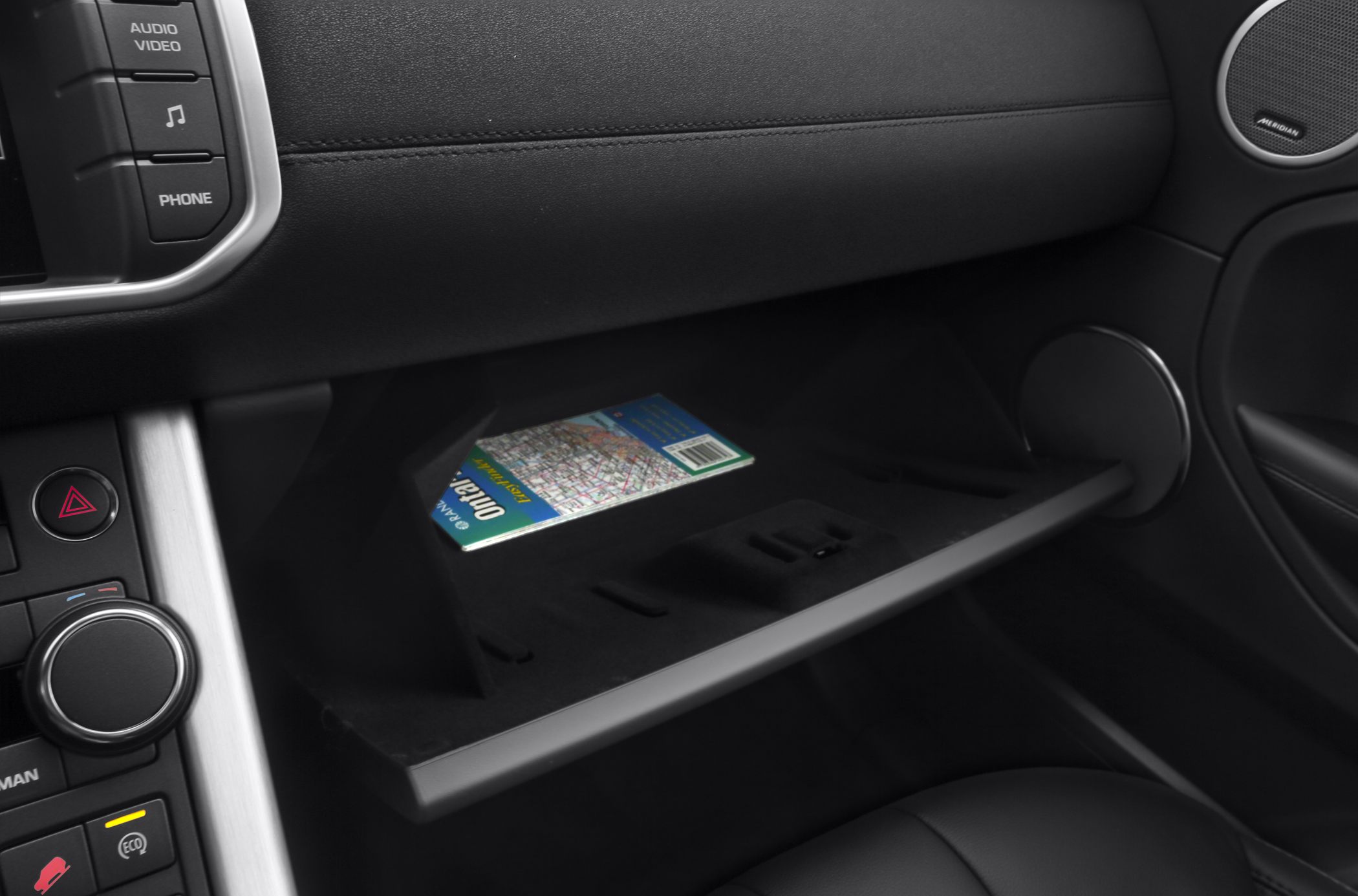 Glove box opened showing storage area inside luxury car interior.