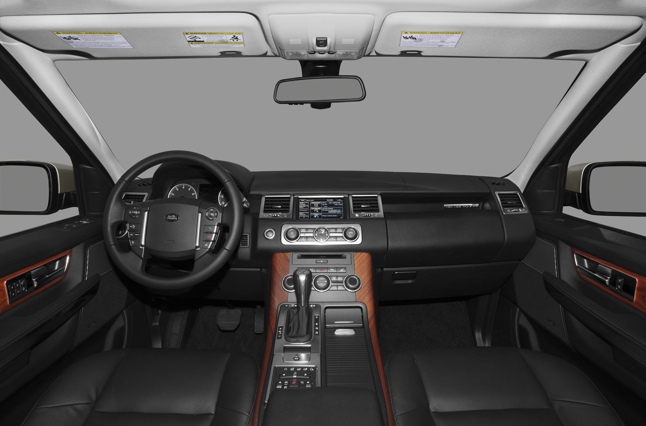 Leather-wrapped steering wheel and wood-paneled center console in SUV interior