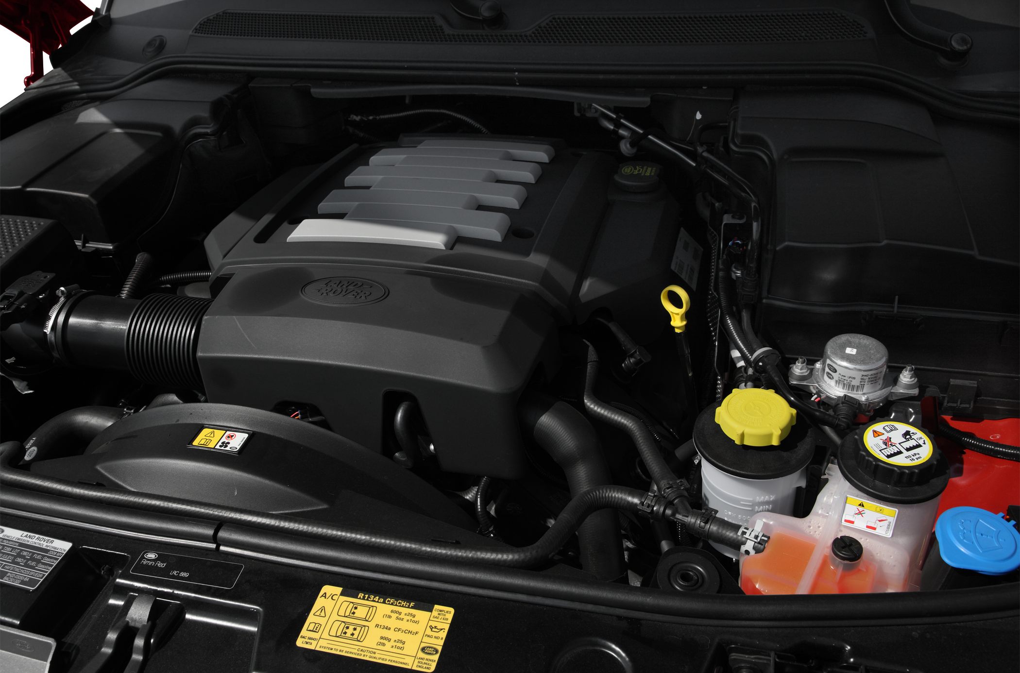 Engine bay with engine cover, fluid reservoirs, and engine components
