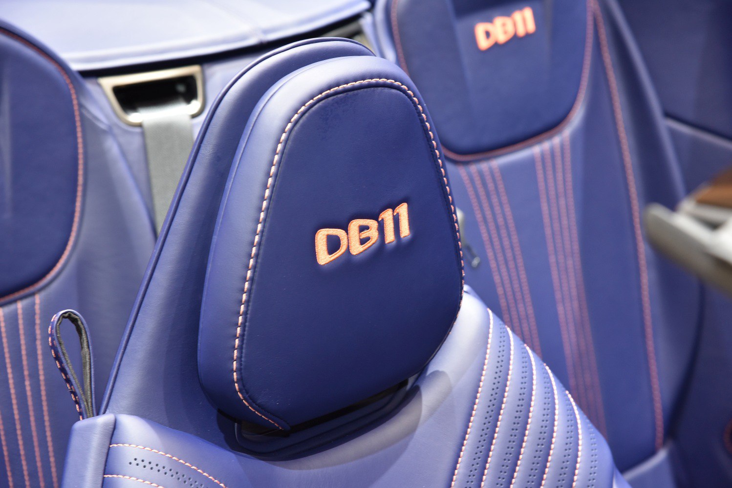 Blue leather seat with orange stitching and embroidered DB11 headrest.
