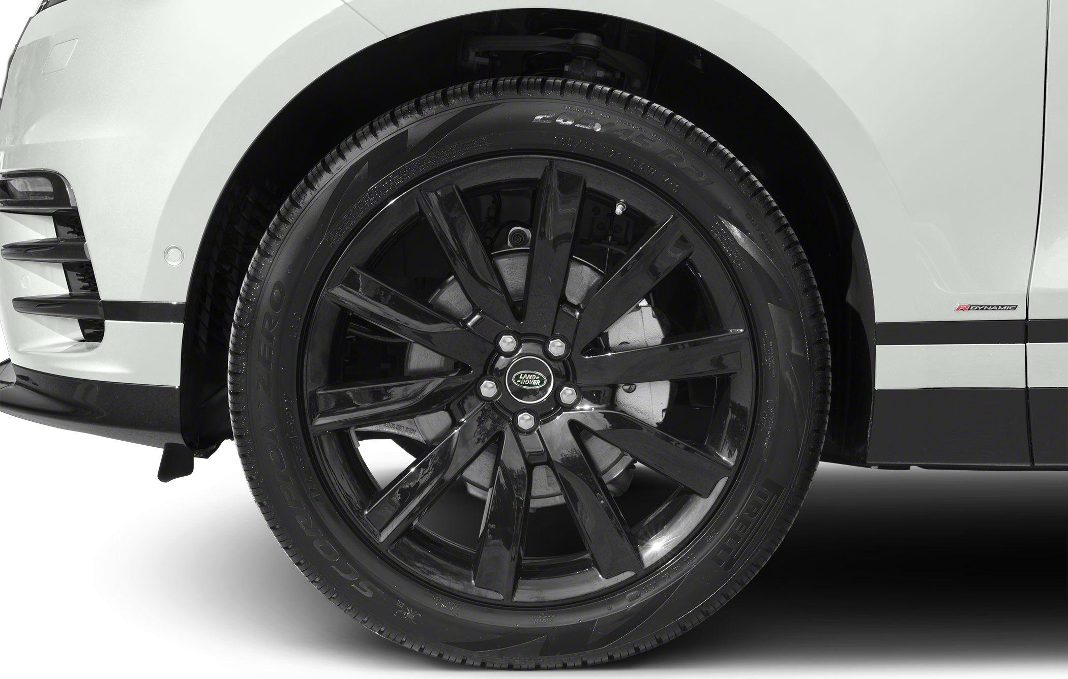 Glossy black multi-spoke alloy wheel with tire and white SUV wheel arch.