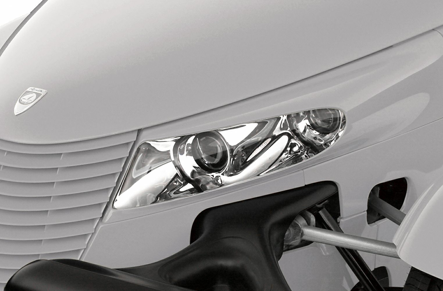 Close-up of front headlight and grille with visible suspension arms