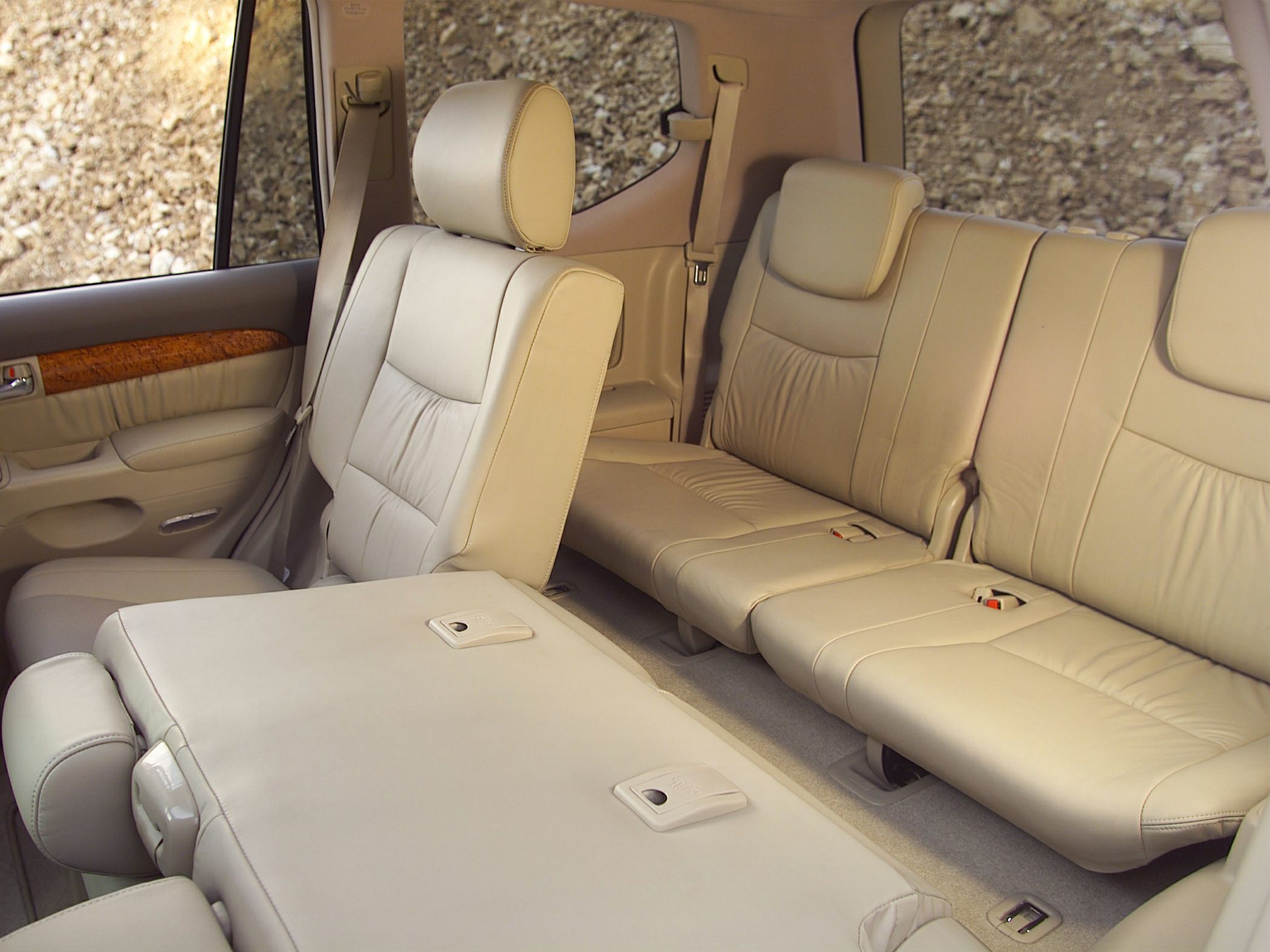 Beige leather rear seats with fold-flat feature and wood trim details