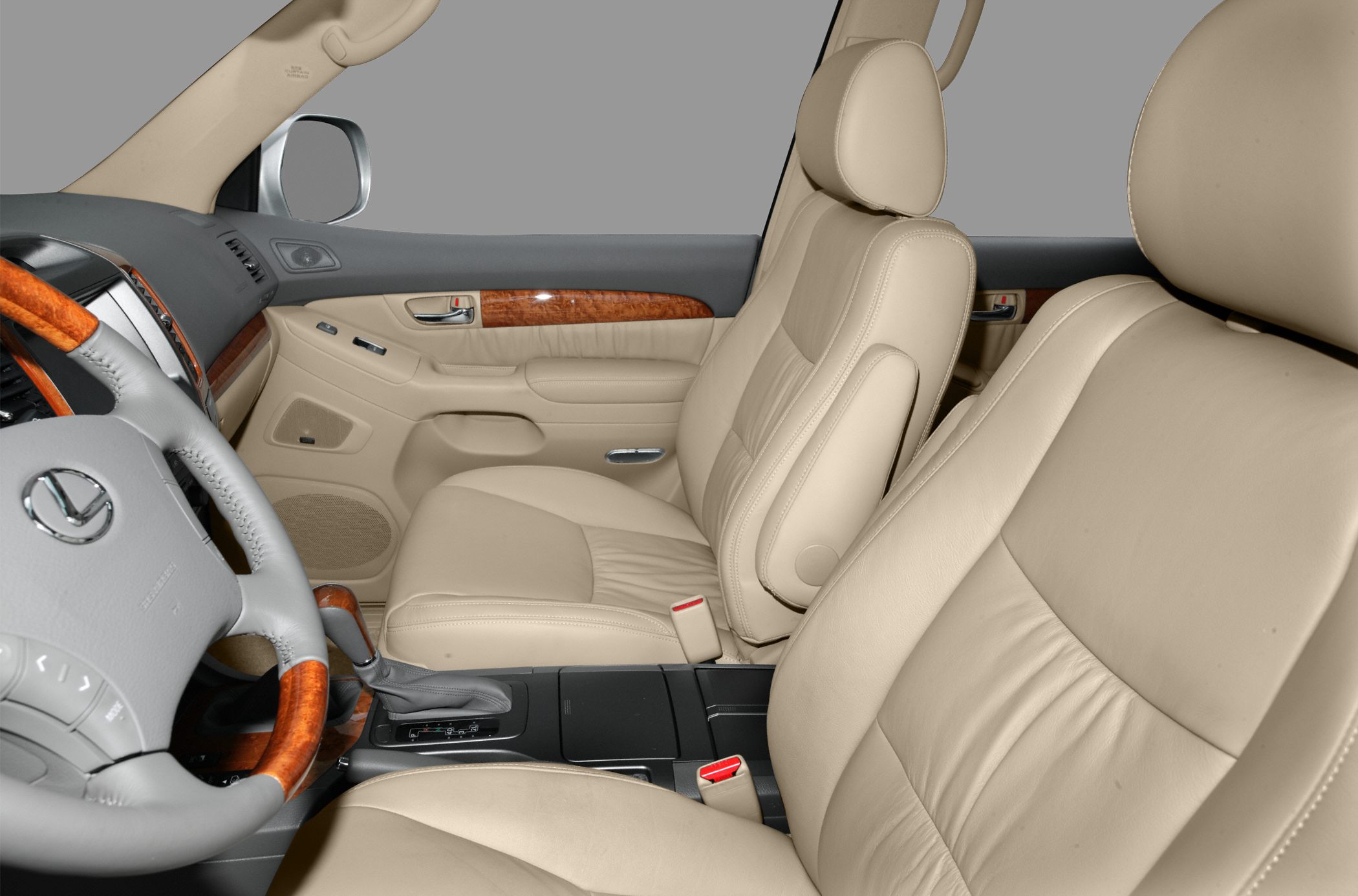 Beige leather seats and wood trim interior with steering wheel and automatic gear shifter