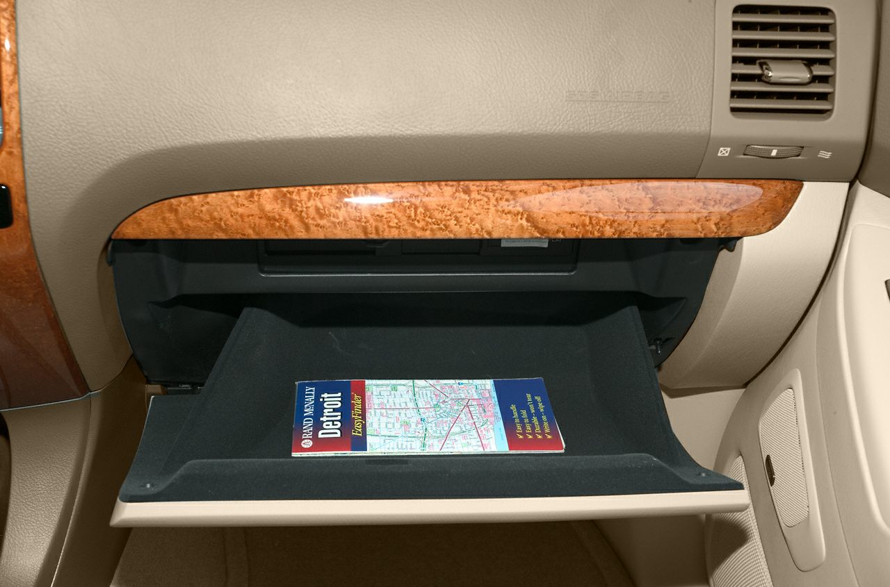 Open glovebox with wood trim and beige dashboard