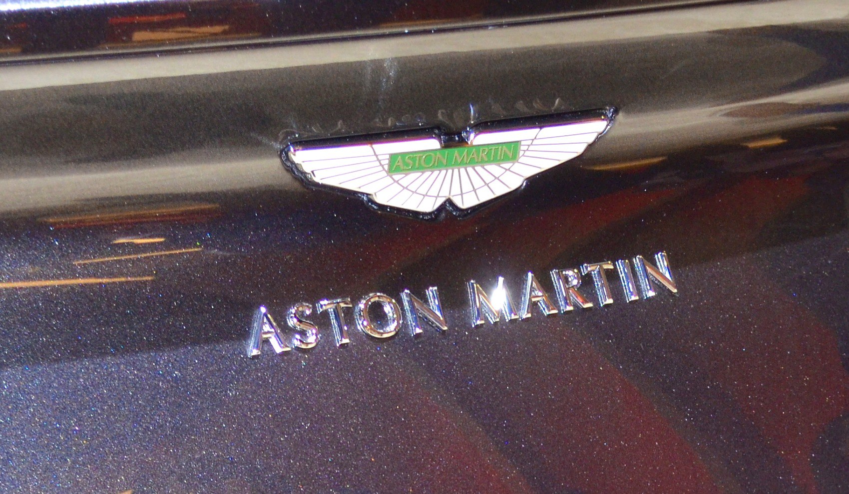 Close-up of Aston Martin emblem and badge on a metallic surface