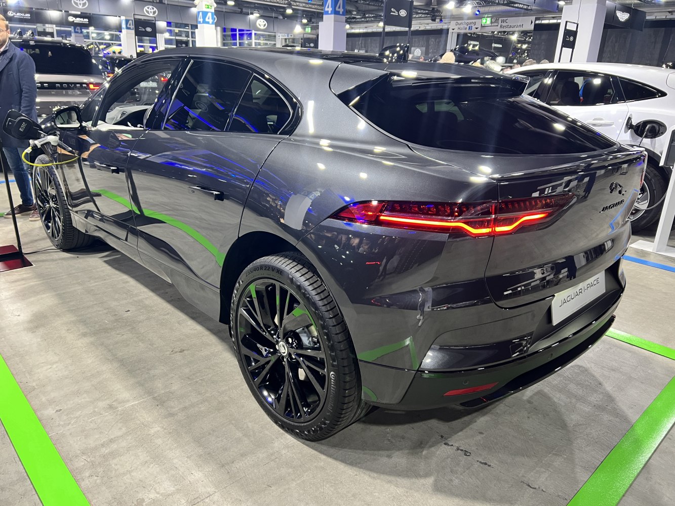 Electric SUV rear-side profile with illuminated taillights and charging cable