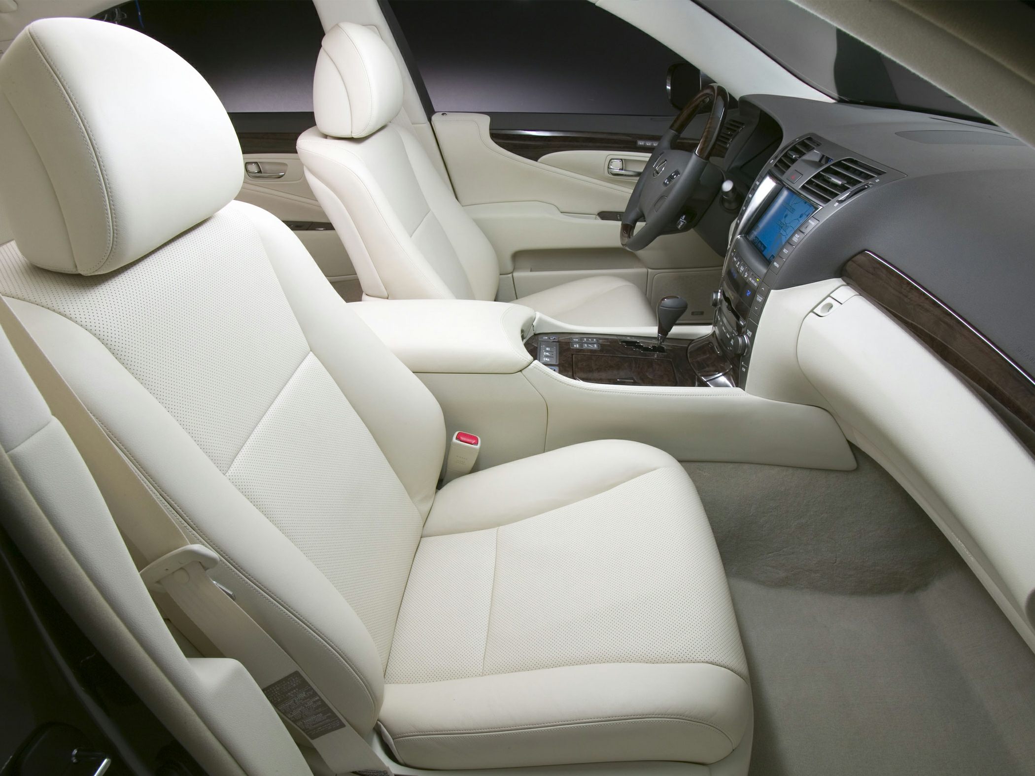 Beige leather seats and wood trim dashboard in luxury car interior.