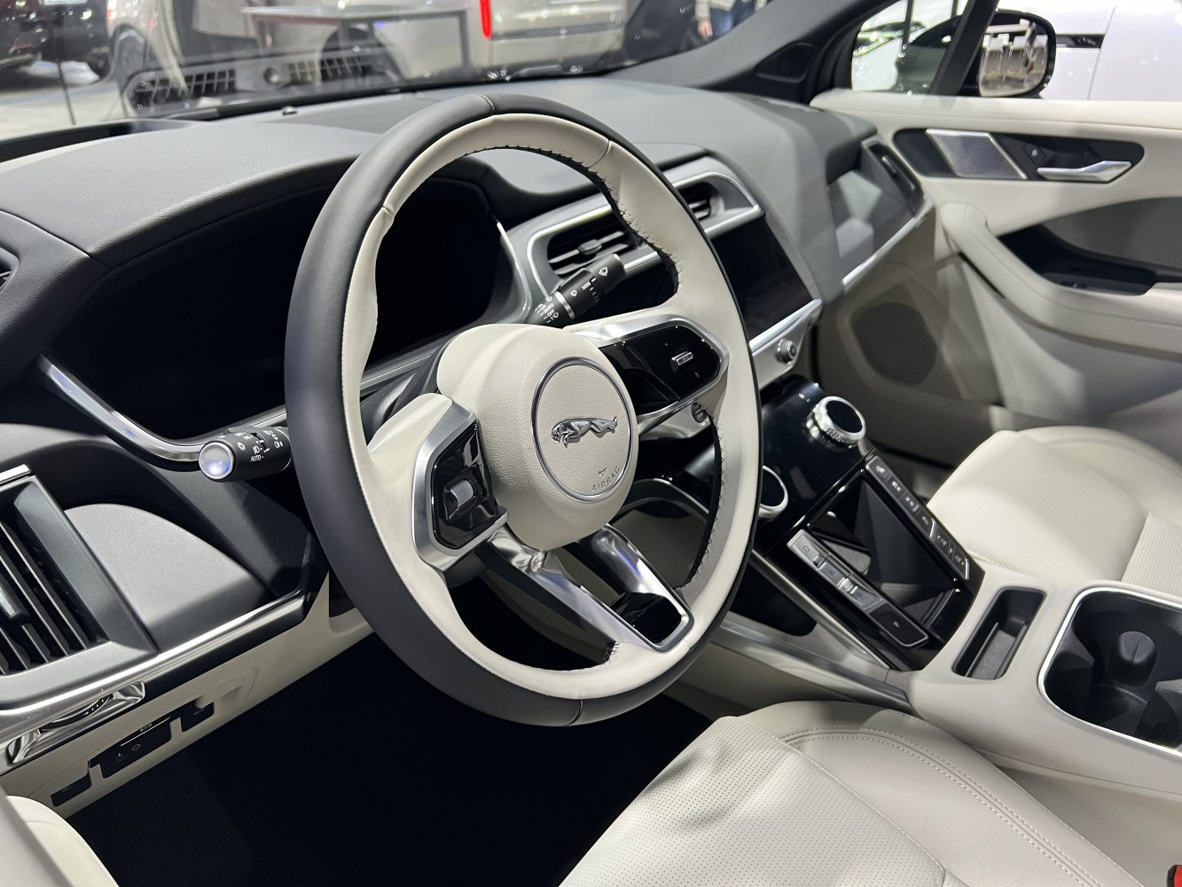 White-trimmed steering wheel and digital dashboard in luxury car interior