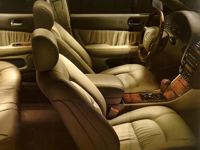 Leather seats and wood trim inside luxury sedan front cabin