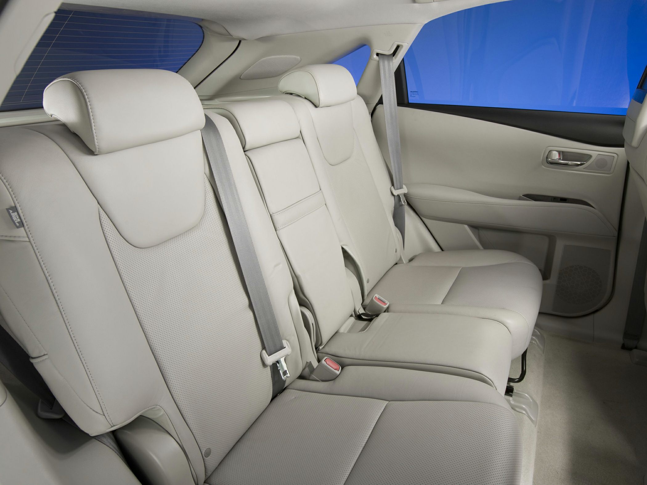 Beige leather rear seats with headrests and seat belts in SUV interior