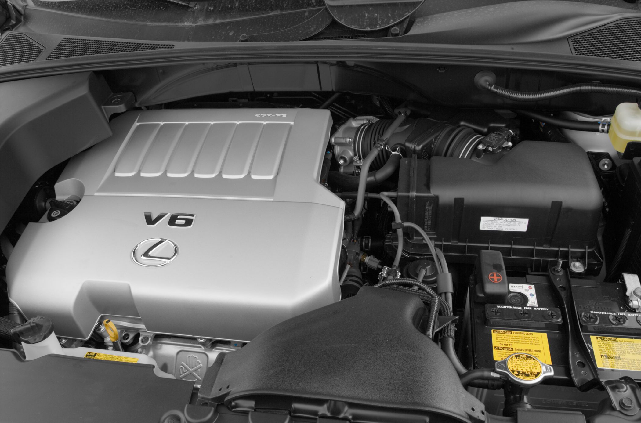 Close-up of V6 engine with cover and battery in engine bay
