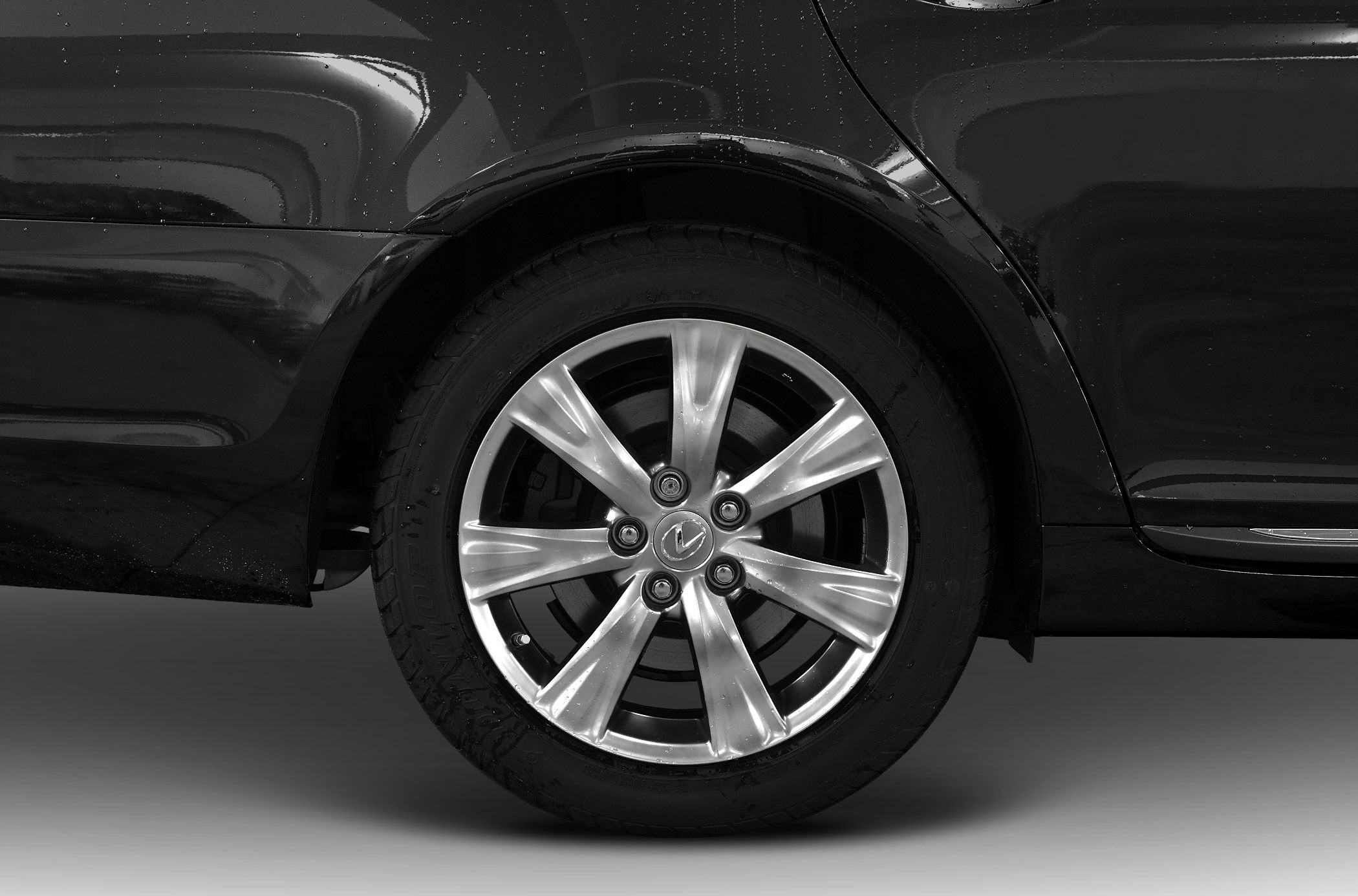 Rear alloy wheel and fender section of a luxury sedan.