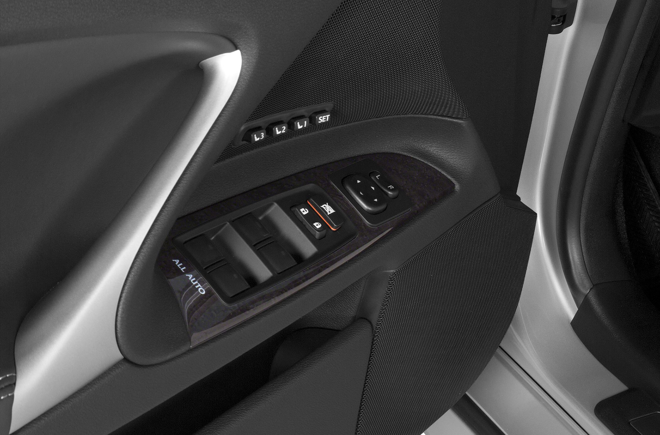Power window controls and memory seat buttons on car door panel.