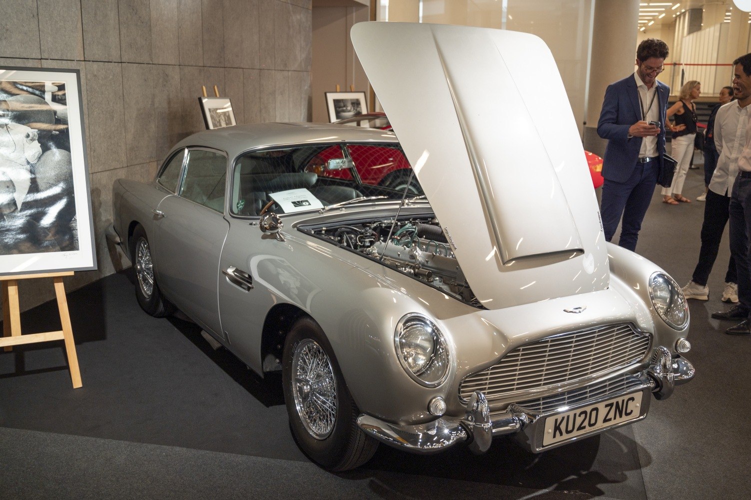 Classic silver coupe with raised hood and visible detailed engine