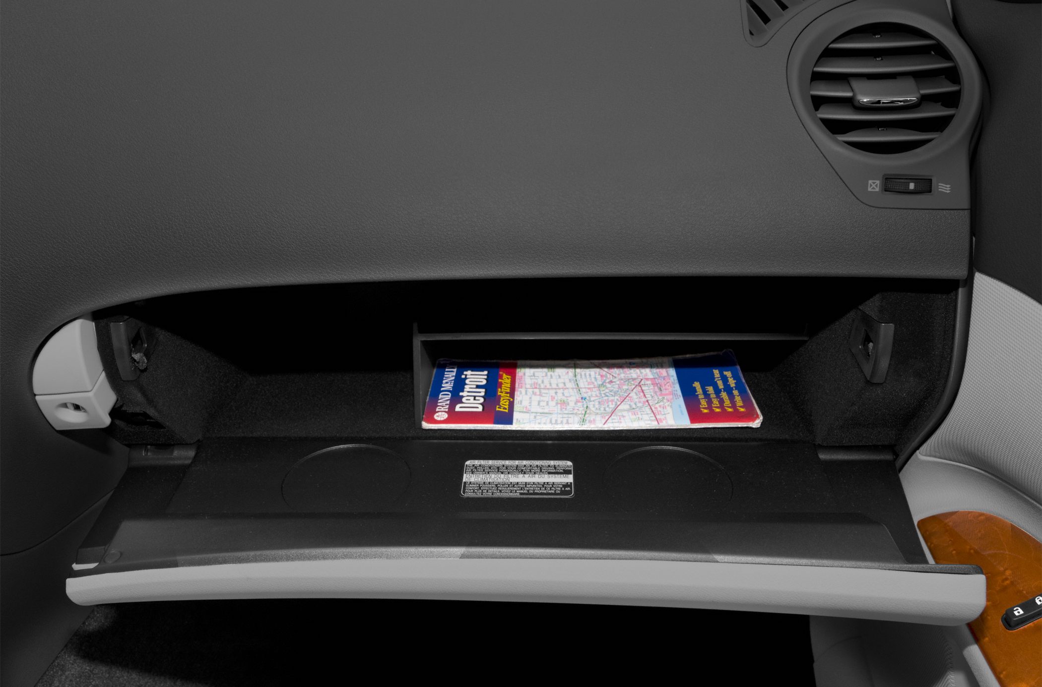 Open glovebox with map inside and nearby air vent