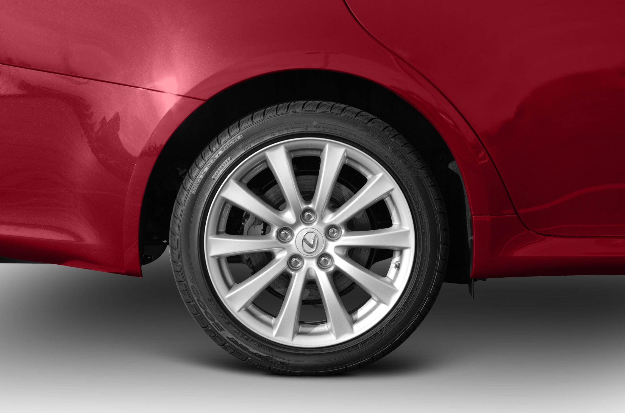 Silver alloy wheel and tire close-up on red car body