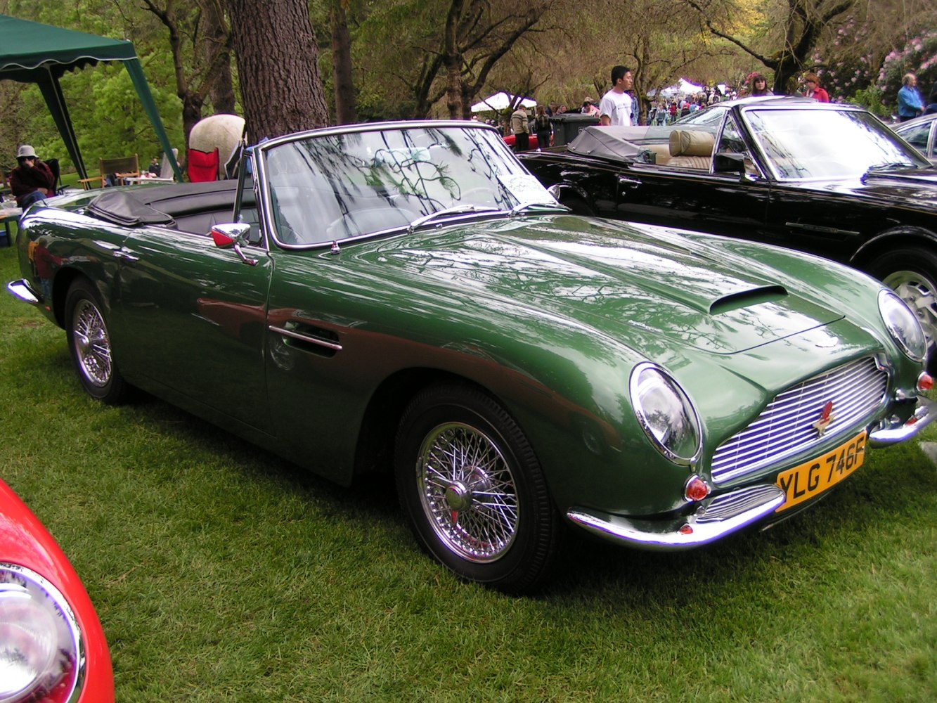 Green convertible with wire-spoke wheels and classic front grille