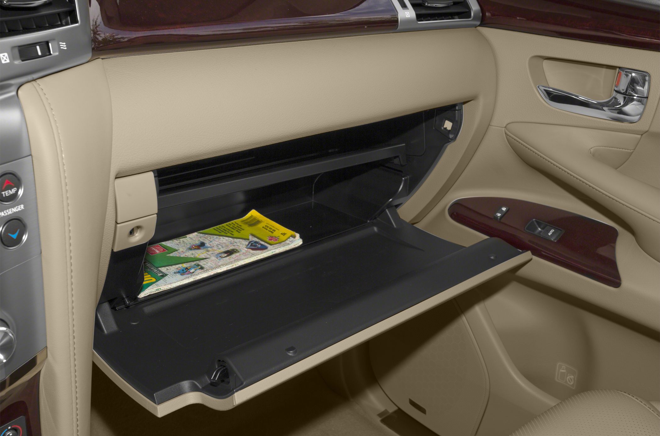 Open glovebox and beige leather passenger door panel with wood trim