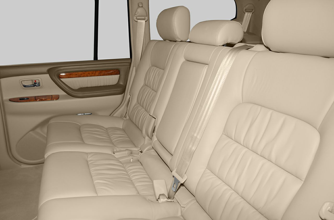 Beige leather rear seats with wood trim and integrated seat belts