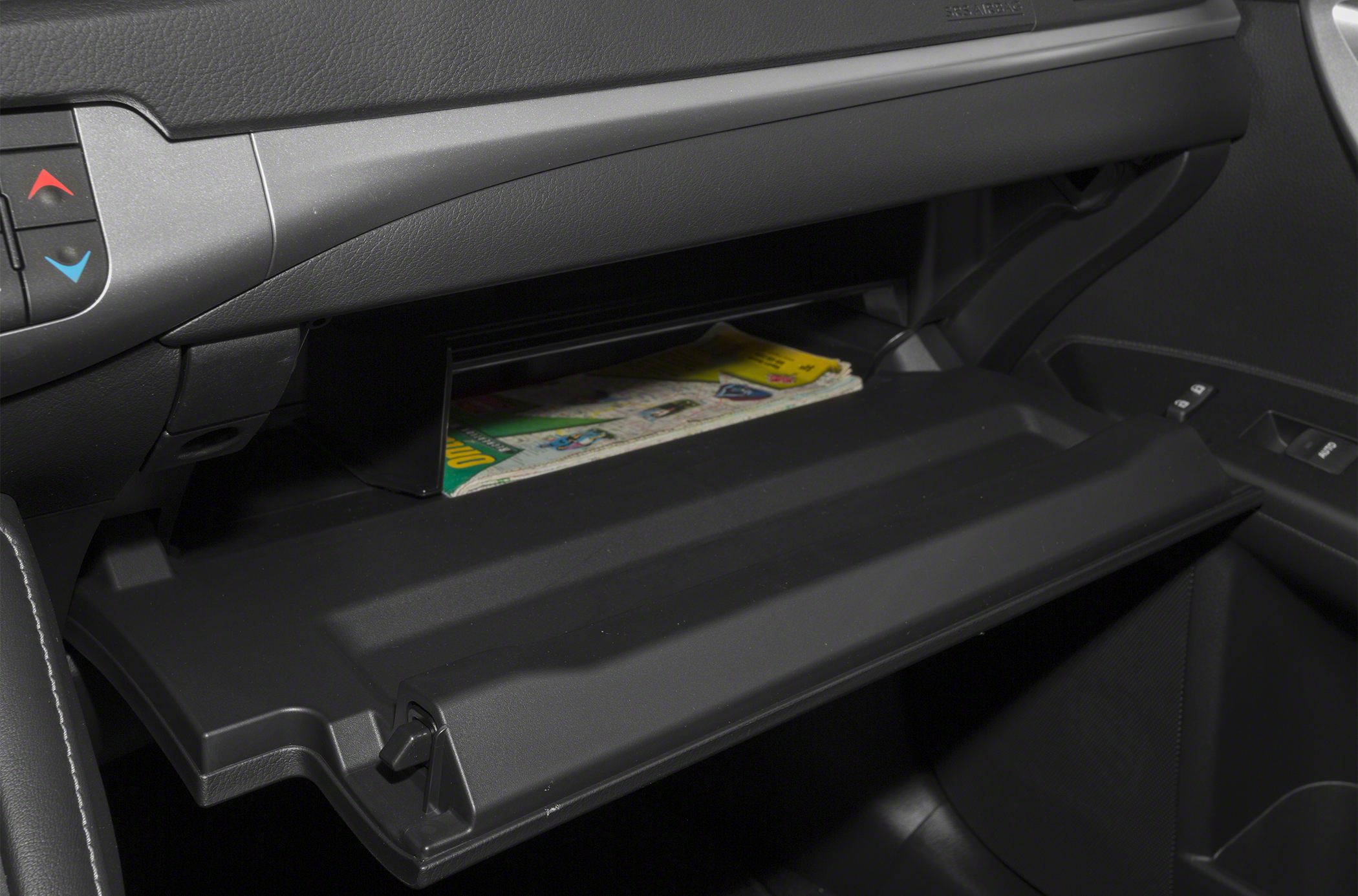Open glove box with interior storage compartment and visible documents.