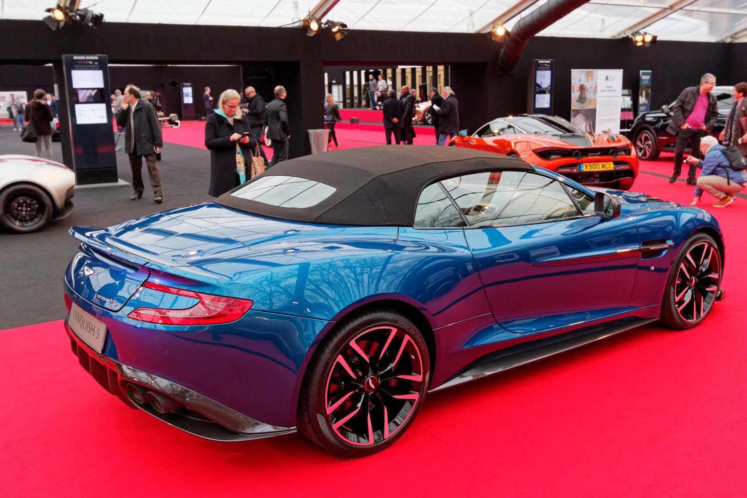Rear and side view of a blue convertible with soft-top roof and sporty design