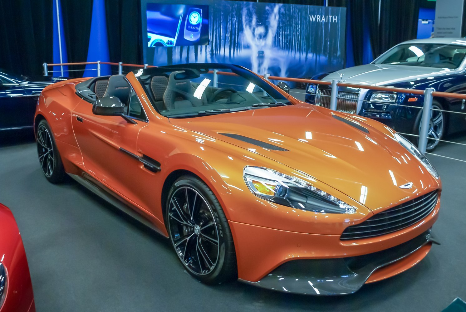 Convertible sports car with carbon fiber hood vents and black multi-spoke wheels