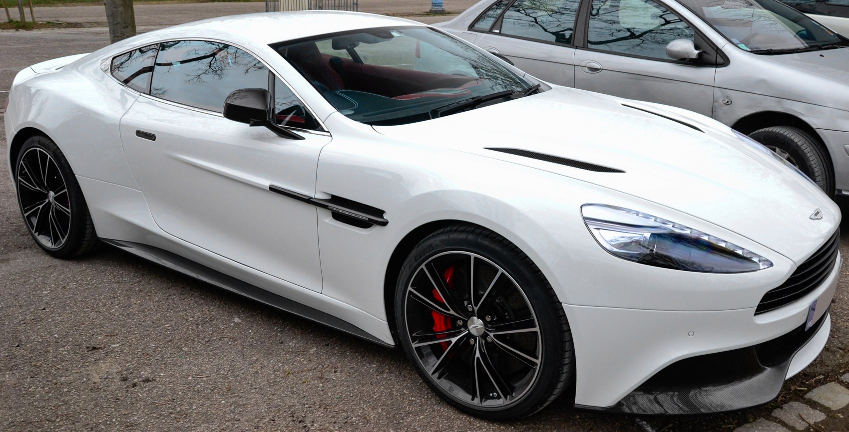 White coupe with aerodynamic design and black multi-spoke alloy wheels