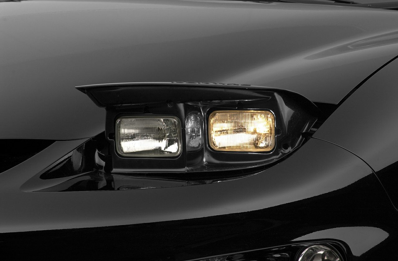 Close-up of pop-up headlights on a classic muscle car