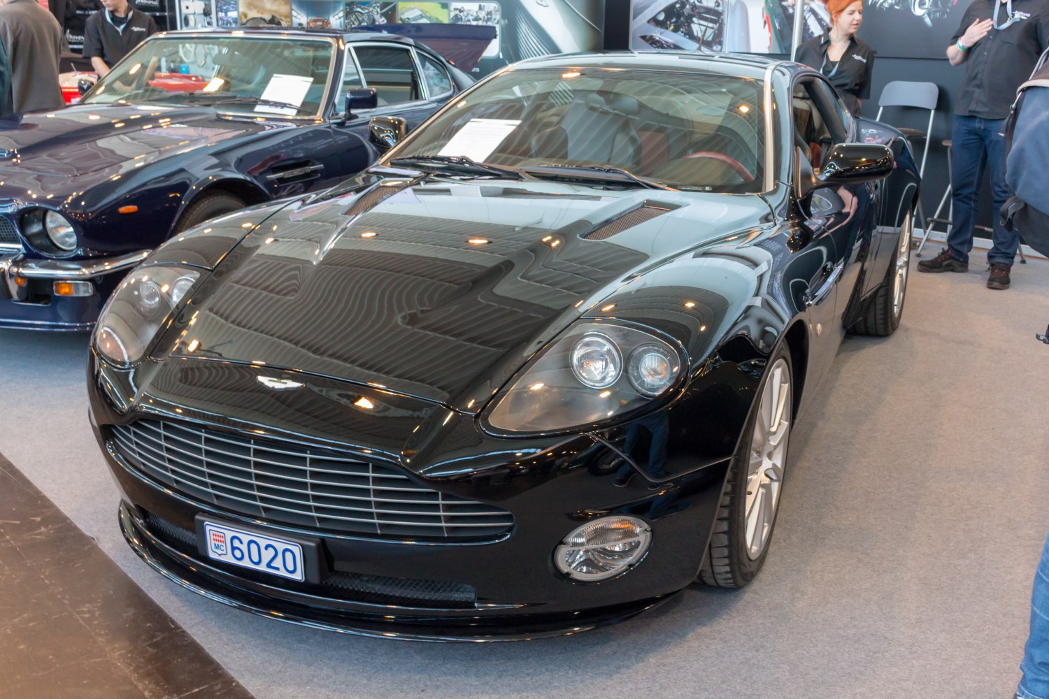 Glossy black sports coupe with bold grille and twin headlights